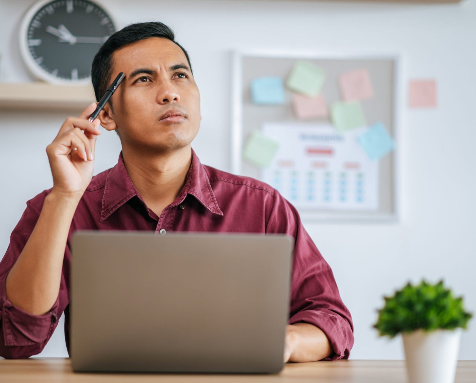 A man works in an office and thinks of fixing tasks.